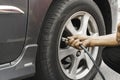 Man driver hand inflating tires of vehicle, removing tire valve nitrogen cap for checking air.