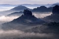 Kleiner Winterberg, beautiful morning view over sandstone cliff into deep misty valley in Saxony Switzerland, landscape in Germany