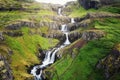 Klifbrekkufossar seven tier waterfall flowing hidden in the Mjoifjordur Fjord on summer at Iceland Royalty Free Stock Photo