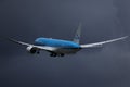 KLM plane flying up in the dark sky, cloudy