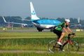 KLM plane taxiing and biker on Polderbaan runway