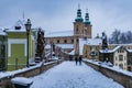Small gothic bridge over Mlynowka river located at city center and covered by fresh snow at winter Royalty Free Stock Photo