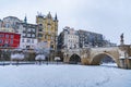 Small gothic bridge over Mlynowka river located at city center and covered by fresh snow at winter Royalty Free Stock Photo