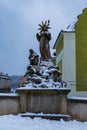 Small old statue on the side of gothic bridge over Mlynowka river covered by snow at winter Royalty Free Stock Photo