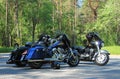 Three black motorcycles in a parking lot in the forest