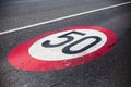 50km/h speed limit sign painted on asphalting road.