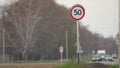 50 km per hour sign. Cars moving along the highway next to a 50kmh speed limit sign. Danger part of the road.