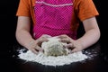 Kneading dough on a black table in a bakery. Baker& x27;s hands prepa Royalty Free Stock Photo