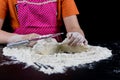 Kneading dough on a black table in a bakery. Baker& x27;s hands prepa Royalty Free Stock Photo