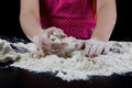 Kneading dough on a black table in a bakery. Baker& x27;s hands prepa Royalty Free Stock Photo