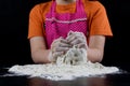Kneading dough on a black table in a bakery. Baker& x27;s hands prepa Royalty Free Stock Photo