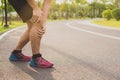 Knee Injuries. Young sport man holding knee with his hands in pain after suffering muscle injury during a running workout at park Royalty Free Stock Photo