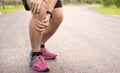 Knee Injuries. Young sport man holding knee with his hands in pain after suffering muscle injury during a running workout at park Royalty Free Stock Photo
