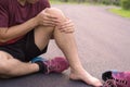 Knee Injuries. Young sport man holding knee with his hands in pain after suffering muscle injury during a running workout at park Royalty Free Stock Photo