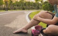 Knee Injuries. Young sport man holding knee with his hands in pain after suffering muscle injury during a running workout at park