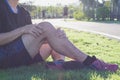 Knee Injuries. Young sport man holding knee with his hands in pain after suffering muscle injury during a running workout at park Royalty Free Stock Photo