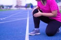 Knee Injuries. Young sport woman holding knee with her hands in pain after suffering muscle injury during a running workout on
