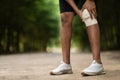 Unrecognizable sportsman wrapping injured knee with elastic bandage