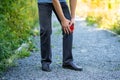 Knee pain when walking outdoors, man with jogging injury Royalty Free Stock Photo