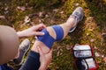 Injured hiker putting elastic bandage to her knee Royalty Free Stock Photo