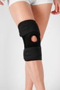 Knee Support Brace on leg isolated on white background. Elastic orthopedic orthosis. Anatomic braces for knee fixation Royalty Free Stock Photo