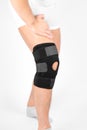 Knee Support Brace on leg  on white background. Elastic orthopedic orthosis. Anatomic braces for knee fixation Royalty Free Stock Photo