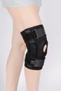 Knee Support Brace on leg  on white background. Elastic orthopedic orthosis. Anatomic braces for knee fixation Royalty Free Stock Photo