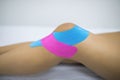 Knee treated with kinesio tex tape therapy. Injured woman knee with tratament of kinesio tape Royalty Free Stock Photo