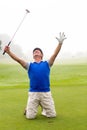 Kneeling golfer cheering on putting green