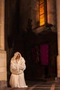 Kneeling monk in dark church