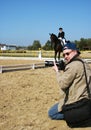 Kneeling Photographer Turned Head, Shoots Outdoor Equestrian Dressage English Riding Sports Competition, Horsewoman Jokey on Horse Royalty Free Stock Photo