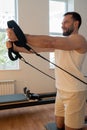 Kneeling pulley exercise, practicing on reformer pulley row focusing on shoulder control Royalty Free Stock Photo