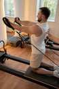 Kneeling pulley exercise, practicing on reformer pulley row focusing on shoulder control Royalty Free Stock Photo
