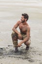 Kneeling Shirtless Soldier on the Beach Sand