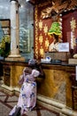 Kneeling woman praying in front of the sacred image of the Lord of Miracles at Minor Basilica of the Lord of Miracles located in
