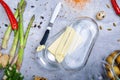 Knife and briquette of margarine. Butter in a glass box and vegetables on a table background. Healthy meal preparation. Royalty Free Stock Photo