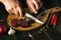 A knife in the chef hand for cutting blood sausage for a very tasty dinner. Cooking a national dish with spices at home Royalty Free Stock Photo