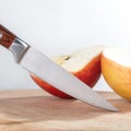 Knife for cleaning fruits and apple on table.