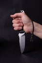 The knife is clenched in the hand. The hand is clenched into a fist