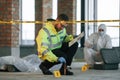Knife clue. Detectives are collecting evidence in a crime scene near dead body. Forensic specialists are making expertise