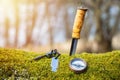 Knife, compass and fire starter on moss in the spring forest. Royalty Free Stock Photo