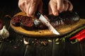 A knife in the cook hand for cutting blood sausage for a very tasty dinner. Cooking a national dish with spices at home Royalty Free Stock Photo