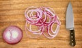 Knife on cutting board and sliced red onion on white Royalty Free Stock Photo