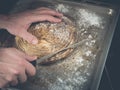 Knife cutting bread into slices on baking tray