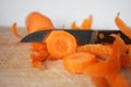 The knife is cutting into the carrot making slices