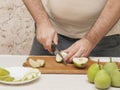 Knife cutting green pears on a cutting board Royalty Free Stock Photo