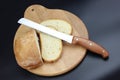 Knife is cutting a loaf of bread into slices. Seed bread, homemade bread,cutting bread Royalty Free Stock Photo