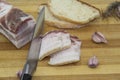 A knife cutting the salo on pieces. Ukrainian products raw lard with peppercorn and garlic, knife, slices of bread, salo lying on Royalty Free Stock Photo