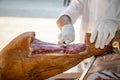 Knife cutting serrano chef man hand slicing of italian dry cured pork cured ham prosciutto Royalty Free Stock Photo