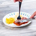 Knife and fork cutting into a TV dinner riblet Royalty Free Stock Photo